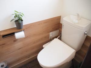 baño con aseo blanco y planta en Lake&Mountain Hamamatsu inn, en Hamamatsu