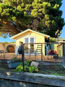 a house with a porch with a table and chairs at Wanderers Cottage in Woodbridge
