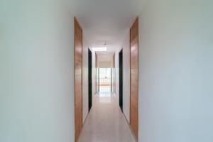 a hallway of a house with wooden doors at Hotel O Oragadam Industrial Estates Chennai Formerly SSM Rooms in Oragadam