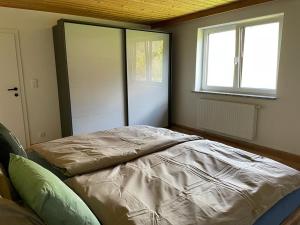 Wohnung am Attersee في شتاينباخ آم أترزي: غرفة نوم بها سرير ونافذة وباب