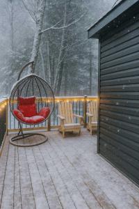 un portico con un'altalena e due sedie nella neve di Lakefront Studio Cottage #7 a Dillon