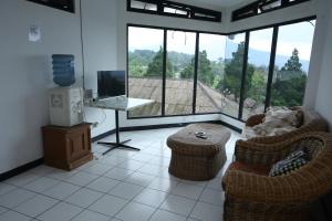 a living room with two chairs and a television and a table at Villa Gunung By ARBA in Pasakon 1