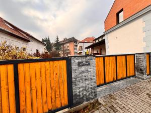 a pair of wooden gates in front of a house at MERKUR APARTMENTS - SELF CHECK-in in Miercurea-Ciuc