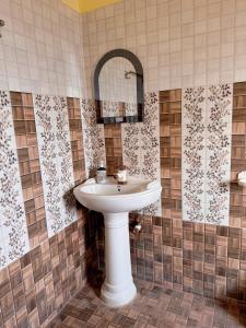 ein Badezimmer mit einem weißen Waschbecken und einem Spiegel in der Unterkunft Studio 305 Signature Heaven in Deoghar