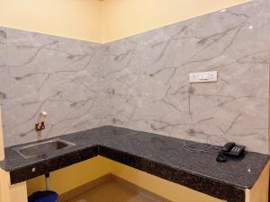 eine Küchentheke mit Spüle und Telefon in der Unterkunft Studio 305 Signature Heaven in Deoghar + 1 Foto