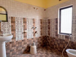 ein gefliestes Badezimmer mit Waschbecken und Toilette in der Unterkunft Studio 305 Signature Heaven in Deoghar