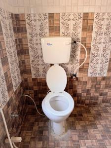 ein Badezimmer mit einer weißen Toilette in einem Zimmer in der Unterkunft Studio 305 Signature Heaven in Deoghar