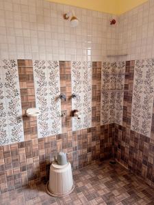 ein gefliestes Badezimmer mit Dusche und Toilette in der Unterkunft Studio 305 Signature Heaven in Deoghar