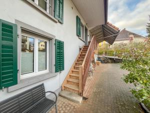 a stairway leading to a building with green shutters at Apartment im Winkel in Reinach