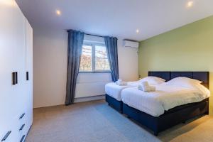 ein Schlafzimmer mit einem großen Bett und einem Fenster in der Unterkunft Welcome in - Vakantiewoning Keetenweg 10 I Met airco en omheinde tuin in Stavenisse