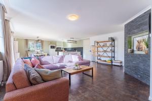 ein Wohnzimmer mit einem lila Sofa und einem Kamin in der Unterkunft Welcome in - Vakantiewoning Keetenweg 10 I Met airco en omheinde tuin in Stavenisse