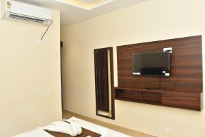 a hotel room with a tv and a bed with towels at Hotel MG Grand in Rāmeswaram +11 photos