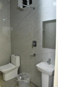 a bathroom with a toilet and a sink at Hotel MG Grand in Rāmeswaram
