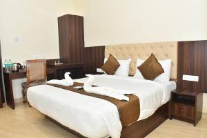 two white swans sitting on a bed in a hotel room at Hotel MG Grand in Rāmeswaram