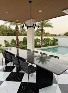 un tavolo da pranzo in una casa con piscina di พูลวิลล่าบุรีรัมย์ a Ban Krasang