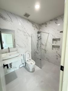 un bagno bianco con un water e un lavandino di พูลวิลล่าบุรีรัมย์ a Ban Krasang