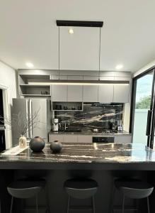 una cucina con bancone e sgabelli di พูลวิลล่าบุรีรัมย์ a Ban Krasang