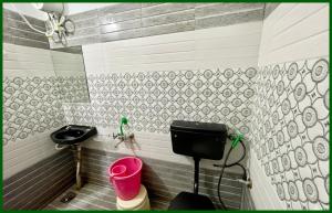 a bathroom with a toilet and a pink bucket at Mahakal Temple Railway station, Salimar Palace - Fully Air conditioned Rooms with Wifi And Parking, , BEST HOTEL IN UJJAIN in Ujjain +5 photos