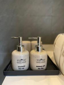 two soap dispensers sitting on a black tray at Tam Coc Hope House in Ninh Binh