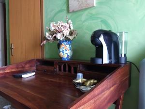 Palazzo Aprile في كالتاجيروني: طاولة خشبية عليها إناء من الزهور