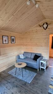 a living room with a blue couch and a table at Webers Tiny House in Rentjärn