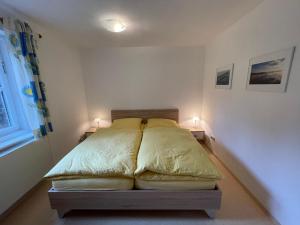a bed in a bedroom with two lamps on two tables at Ferienwohnung Maslanka EG in Utting am Ammersee