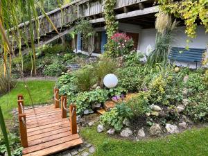 un giardino con una panchina di legno nel cortile di Ferienwohnung Kugler a Grafrath