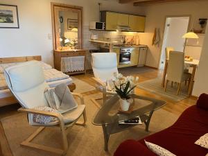 un soggiorno con un divano, sedie e un tavolo di Ferienwohnung Kugler a Grafrath