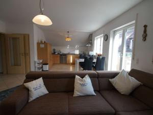 - un salon avec un canapé marron et des oreillers dans l'établissement Ferienwohnung Monika, à Eching