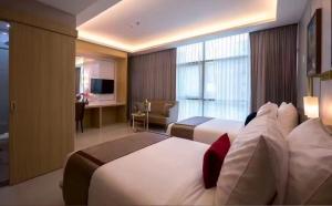 Una habitación de hotel con dos camas y un escritorio. en Lee Airport Hotel 李酒店机场店, en Phrawet