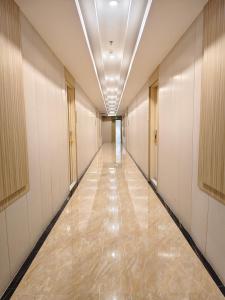 Un pasillo vacío en un edificio con un pasillo largo. en Lee Airport Hotel 李酒店机场店, en Phrawet