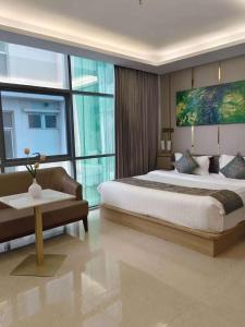 Un dormitorio con una cama grande y una ventana grande. en Lee Airport Hotel 李酒店机场店, en Phrawet