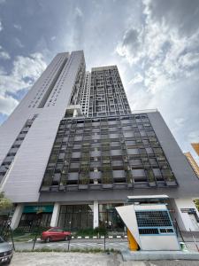 een hoog gebouw met een rode auto ervoor bij Chambers Klcc Suites Esten in Kuala Lumpur