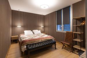 a bedroom with a bed and two chairs at Le Refuge des Isards - Chalet familial in Cauterets