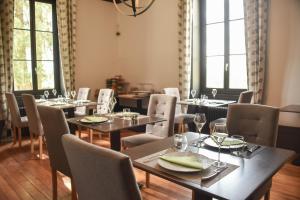 a dining room with tables and chairs and windows at CLOS MARIE in Iguerande