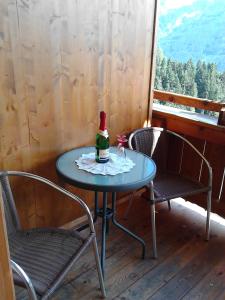 a table with a bottle of wine and two chairs at Pfaffenreitherhof in Uttendorf