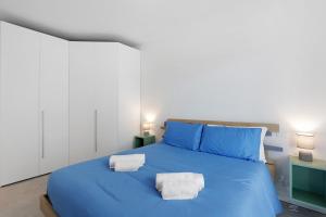 a blue bed with two towels on top of it at Albiceleste Prime Location in Peschiera del Garda