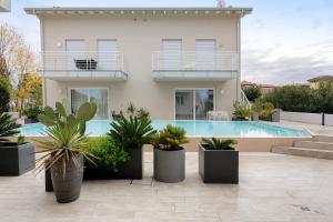 a house with a swimming pool and potted plants at Albiceleste Prime Location in Peschiera del Garda