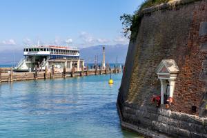 a boat is docked at a dock with a cruise ship at Albiceleste Prime Location in Peschiera del Garda