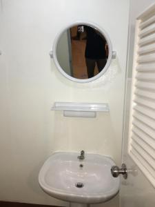 a bathroom with a white sink and a mirror at Lucky Guest House in Phi Phi Islands