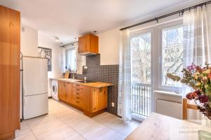 a kitchen with a white refrigerator and a window at Śliska Residence in Warsaw