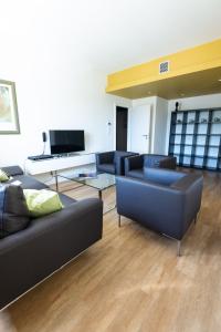 una sala de estar con 2 sofás y un piano en Appart'hotel Urban Lodge, en Chaudfontaine