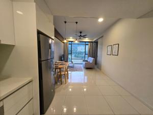 Una cocina y una sala de estar con refrigerador y una mesa. en Cozy Ridge Stay KL East Mall Residence Tower, en Kuala Lumpur 1 foto más