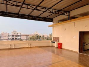 ein leerer Raum mit Holzboden und einem großen Fenster in der Unterkunft Studio 306 Royal Urban in Deoghar