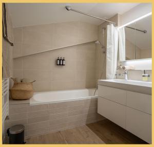 ein Badezimmer mit Badewanne und Waschbecken in der Unterkunft Le Cocon Alpin I Megève in Megève + 30 Fotos