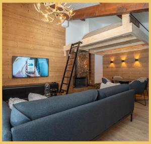 ein Wohnzimmer mit Sofa und Fernseher in der Unterkunft Le Cocon Alpin I Megève in Megève