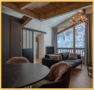 ein Wohnzimmer mit Sofa und Tisch in der Unterkunft Le Cocon Alpin I Megève in Megève