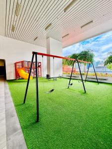 een gymzaal met twee schommels en groen gras bij Chambers Klcc Suites Esten in Kuala Lumpur