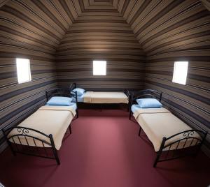 Golden Day Bedouin Camp في وادي رم: غرفة بثلاث اسرة في كابينة خشبية