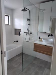 Un baño con bañera, lavabo y ducha. en Capel Breeze, en Capel Sound